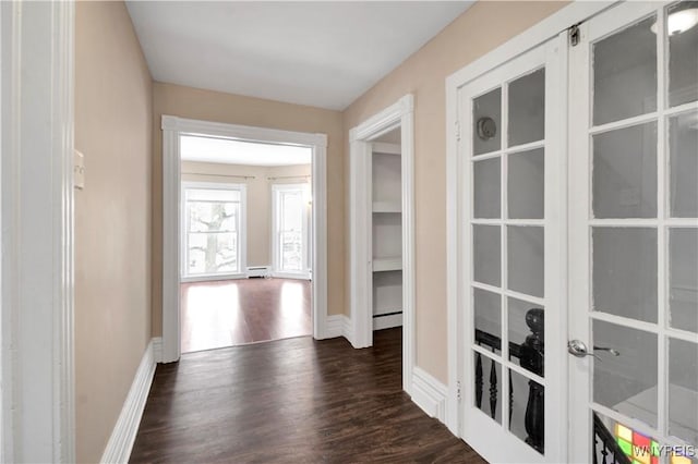 hallway with dark hardwood / wood-style flooring, a baseboard radiator, and french doors