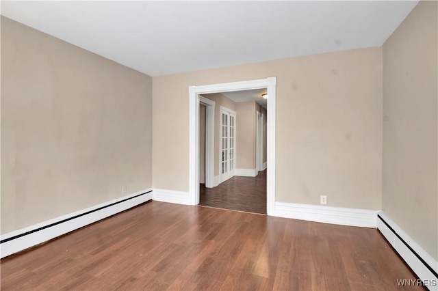 unfurnished room with dark hardwood / wood-style floors and a baseboard heating unit