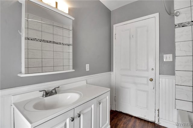 bathroom featuring hardwood / wood-style floors, vanity, and a tile shower