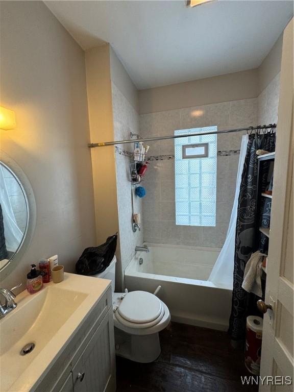 full bathroom with vanity, shower / bath combo, and toilet