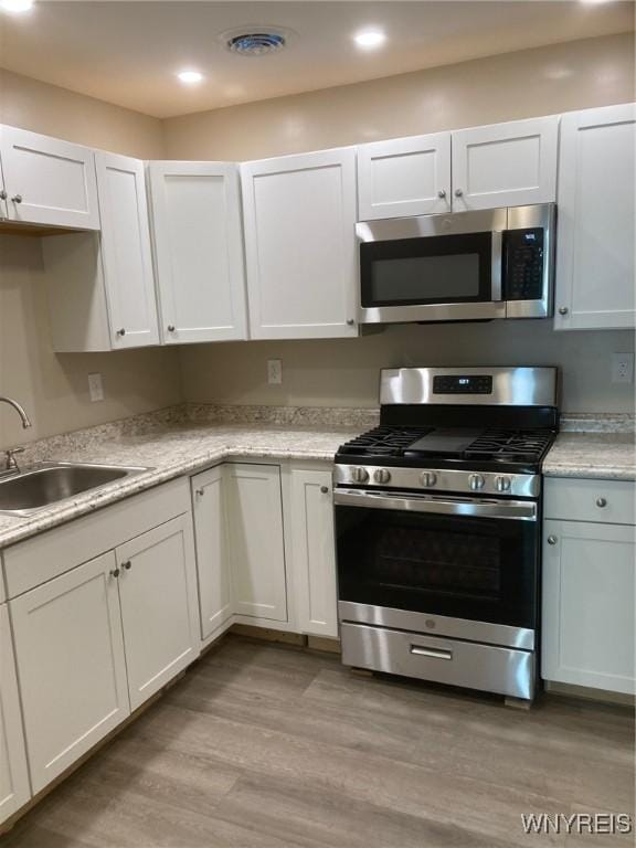 kitchen with sink, white cabinetry, and stainless steel appliances