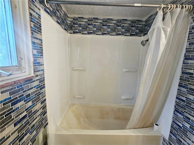 bathroom with tile walls and shower / tub combo