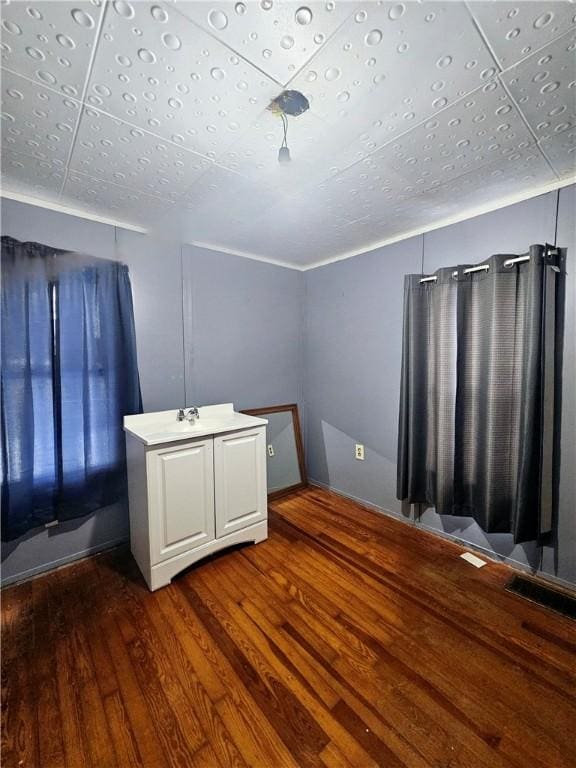 unfurnished bedroom featuring sink and dark wood-type flooring