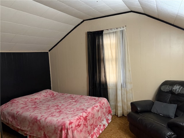 bedroom with wood walls, carpet floors, and vaulted ceiling