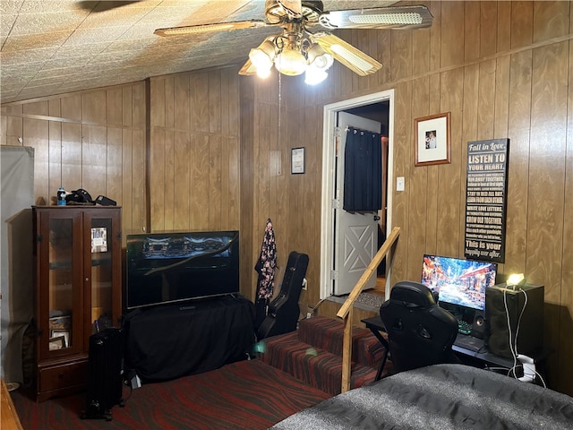 living room featuring wooden walls, ceiling fan, and lofted ceiling