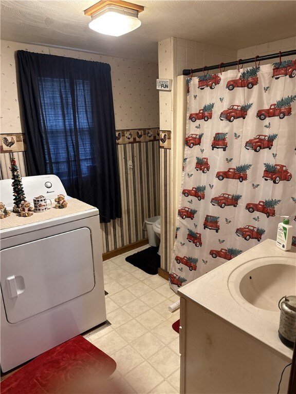 clothes washing area with washer / clothes dryer and sink