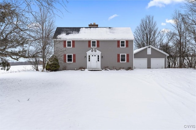 colonial home with a garage and an outbuilding