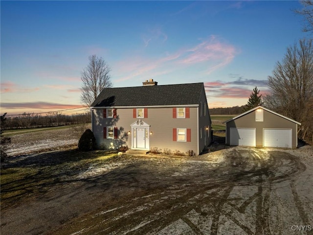 view of front of property with a garage and an outbuilding