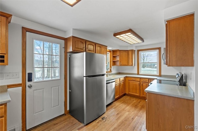 kitchen with light wood-type flooring, stainless steel appliances, plenty of natural light, and sink