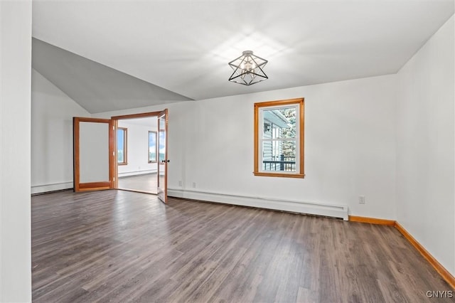 empty room featuring dark hardwood / wood-style floors, vaulted ceiling, and a baseboard heating unit