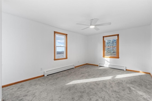 spare room featuring ceiling fan, light colored carpet, and a baseboard heating unit