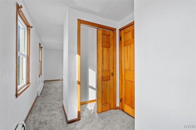 corridor featuring light carpet and a baseboard radiator