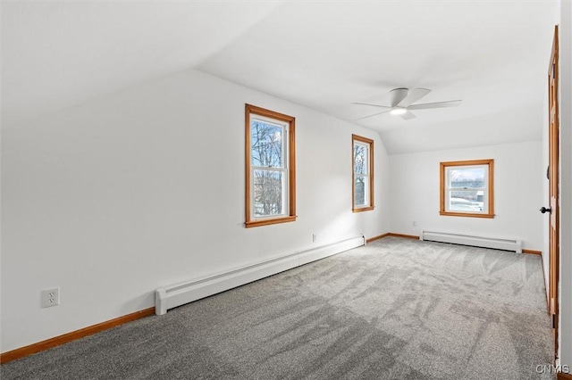 bonus room featuring plenty of natural light, vaulted ceiling, and a baseboard heating unit