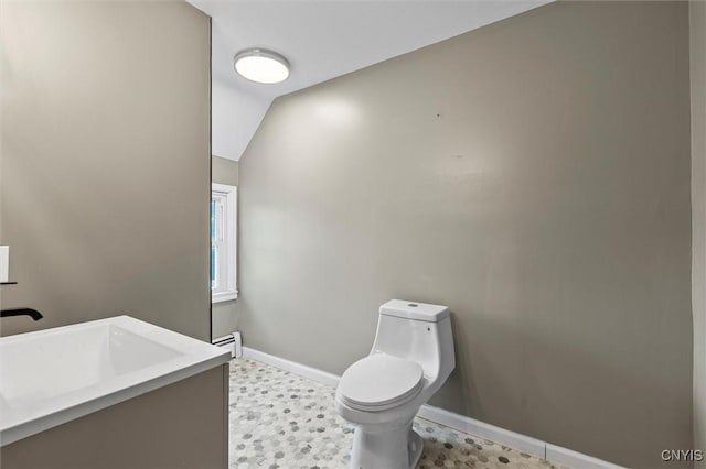 bathroom featuring vanity, toilet, lofted ceiling, and baseboard heating