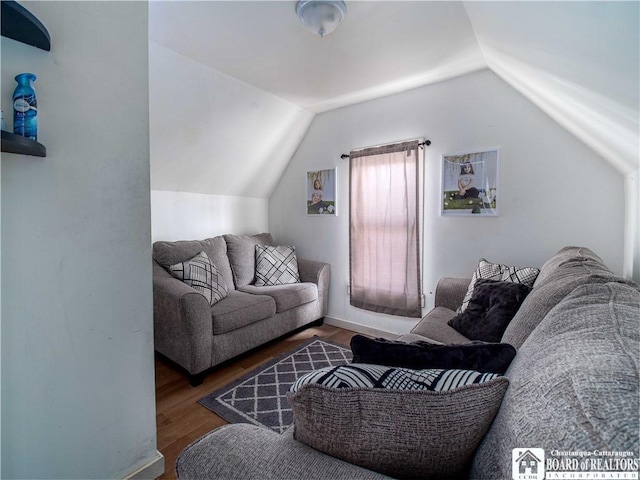 living room featuring dark hardwood / wood-style flooring and vaulted ceiling