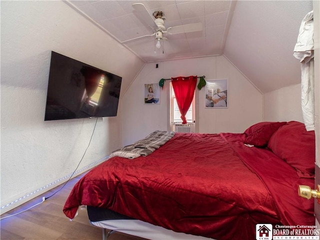 bedroom featuring ceiling fan, hardwood / wood-style floors, and vaulted ceiling