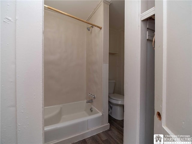 bathroom with hardwood / wood-style flooring, toilet, and shower / washtub combination