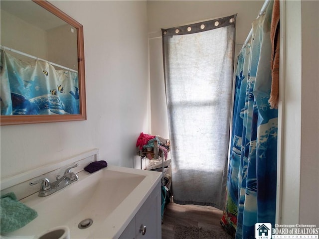 bathroom with curtained shower, hardwood / wood-style floors, and vanity