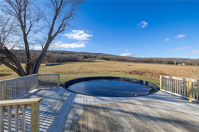 wooden terrace with a lawn and a rural view