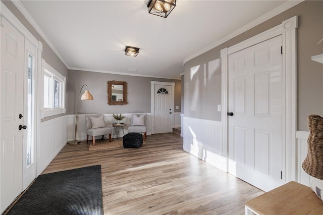 entrance foyer featuring crown molding and light hardwood / wood-style floors