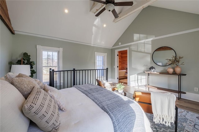 bedroom with hardwood / wood-style floors, ceiling fan, high vaulted ceiling, and ensuite bath