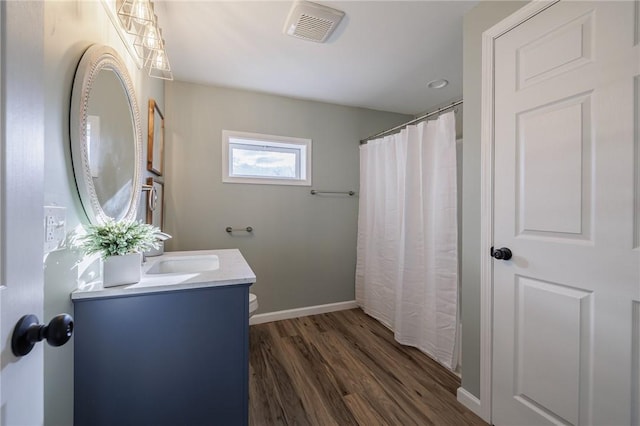 bathroom with hardwood / wood-style floors, vanity, and toilet