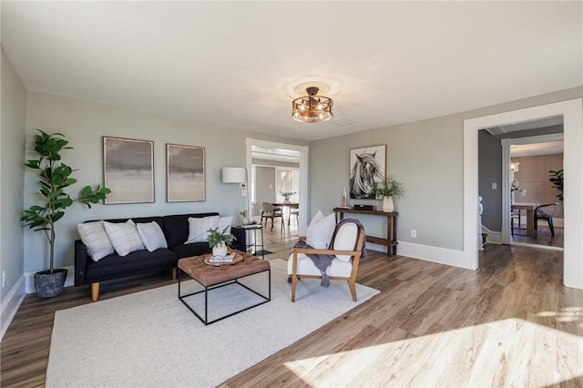 living room with a chandelier and wood-type flooring