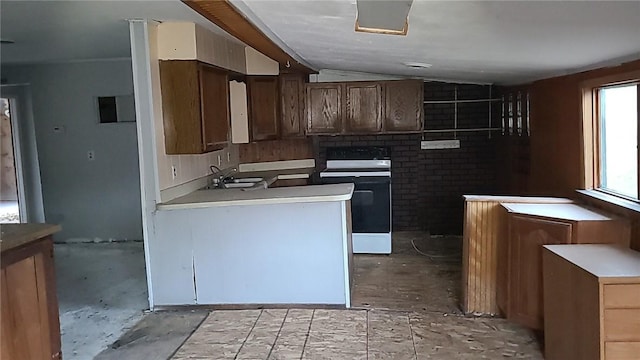 kitchen with vaulted ceiling, sink, and white stove