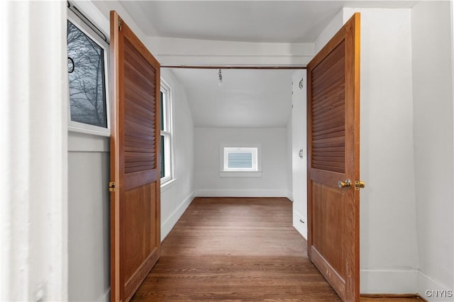 hallway featuring hardwood / wood-style floors and vaulted ceiling