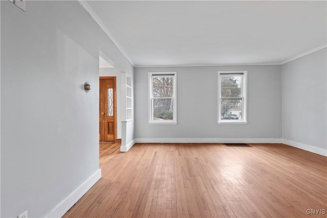 spare room featuring light hardwood / wood-style flooring and ornamental molding