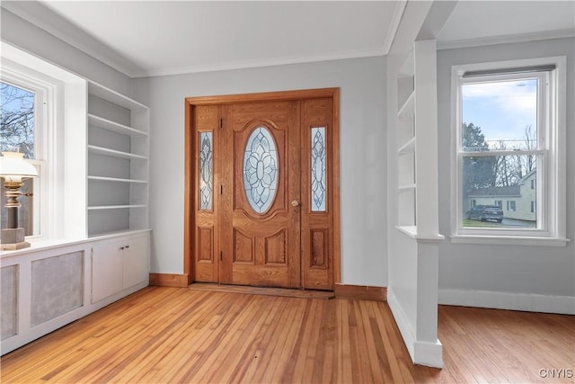 entryway with crown molding, plenty of natural light, and light wood-type flooring