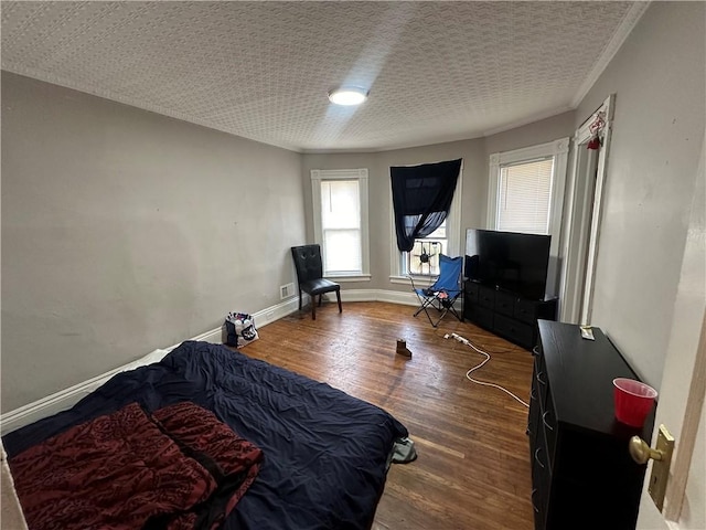 bedroom with a textured ceiling and dark wood-type flooring