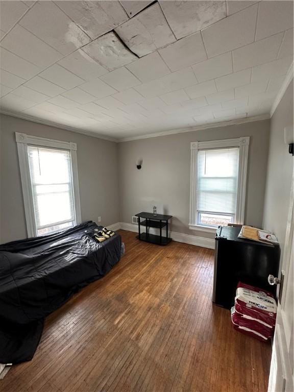 bedroom with multiple windows, crown molding, and wood-type flooring