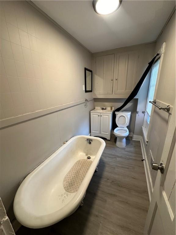 bathroom with hardwood / wood-style flooring, a bathtub, toilet, and sink