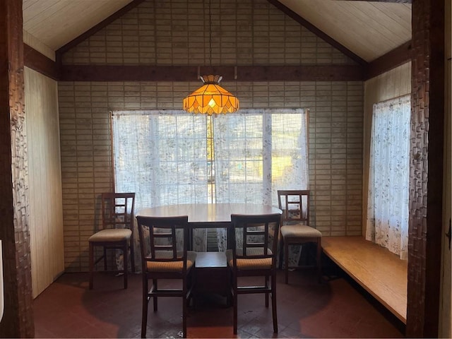 dining space with a healthy amount of sunlight, wooden walls, and lofted ceiling