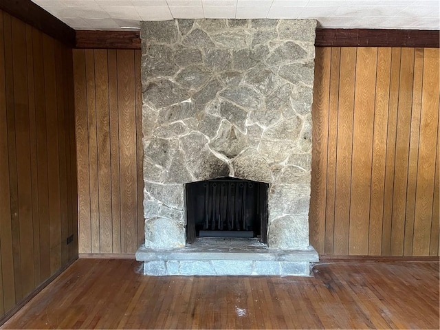 details with a fireplace, wood walls, and hardwood / wood-style floors