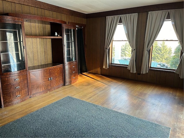 unfurnished room featuring light hardwood / wood-style floors and wooden walls