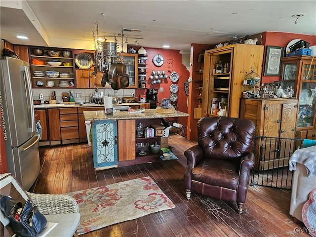 kitchen featuring stainless steel refrigerator, a center island, and dark hardwood / wood-style floors