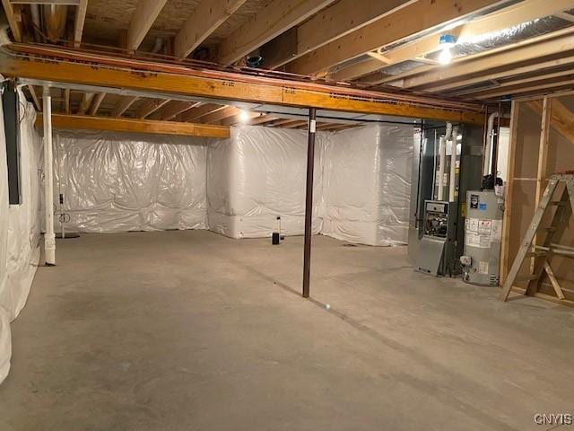 basement featuring heating unit and water heater