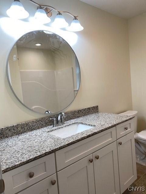 bathroom featuring tile patterned floors, vanity, and toilet