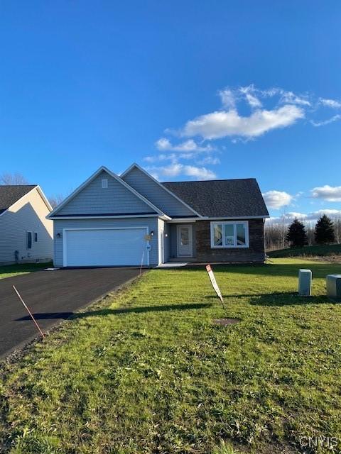 single story home with a garage and a front lawn