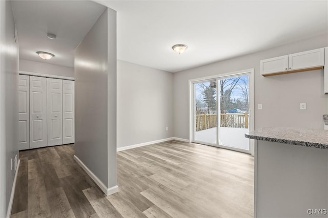 unfurnished dining area featuring light wood-type flooring