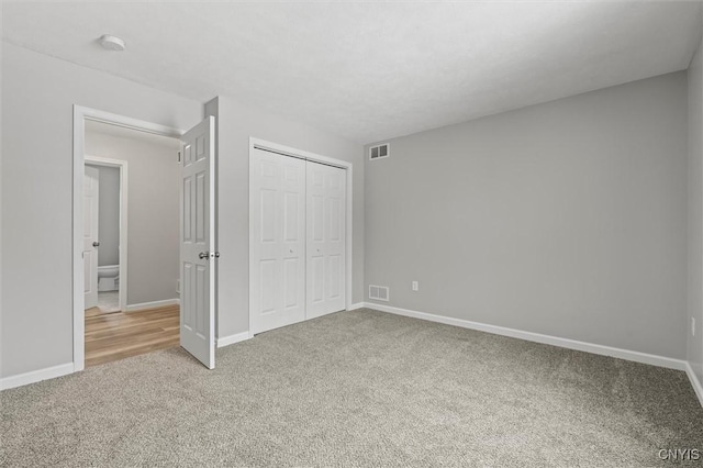 unfurnished bedroom with carpet flooring and a closet