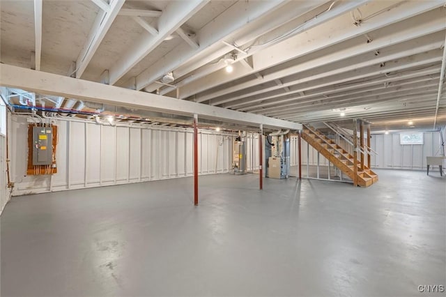 basement featuring electric panel, heating unit, and gas water heater