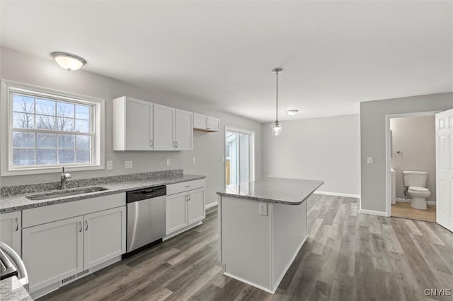 kitchen featuring sink, hardwood / wood-style flooring, dishwasher, white cabinetry, and hanging light fixtures