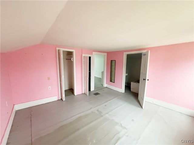 unfurnished bedroom featuring lofted ceiling