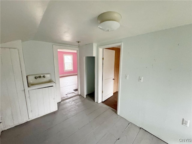 interior space featuring light wood-type flooring, lofted ceiling, and sink