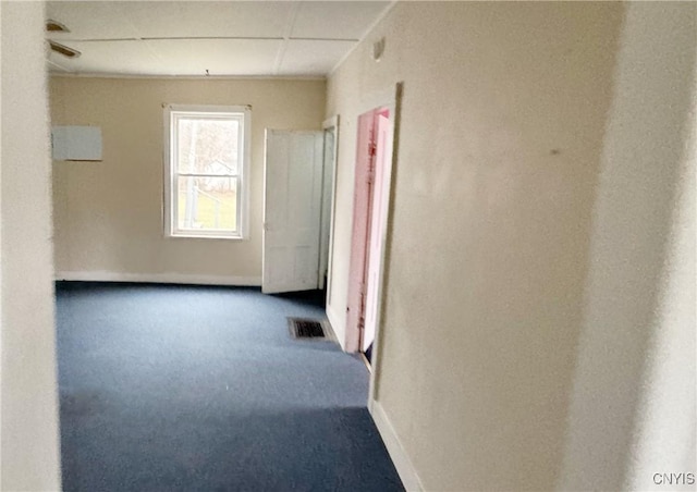 corridor with carpet flooring and a paneled ceiling