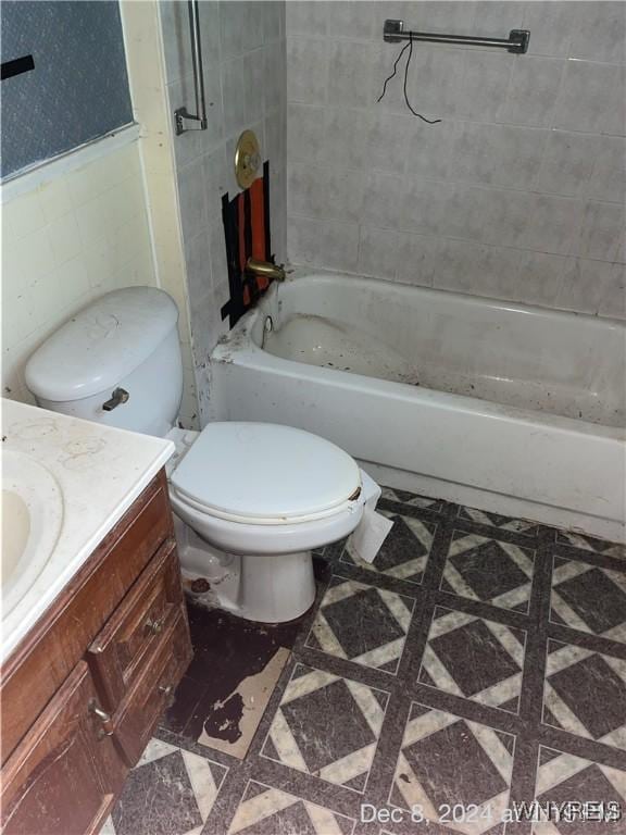 full bathroom featuring tile patterned floors, vanity, tile walls, toilet, and tiled shower / bath