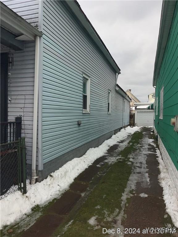 view of snowy exterior with an outbuilding and a garage